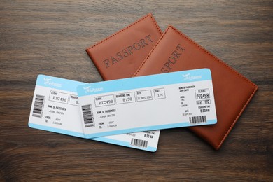 Photo of Travel agency. Flight tickets and passports on wooden table, flat lay