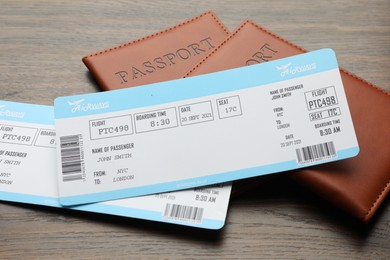 Photo of Travel agency. Flight tickets and passports on wooden table, closeup