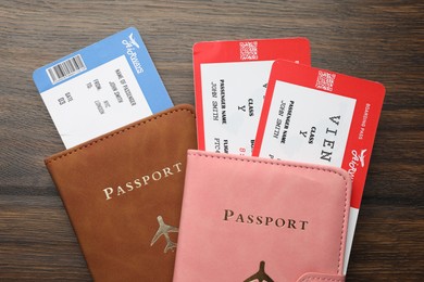 Photo of Travel agency. Flight tickets and passports on wooden table, flat lay