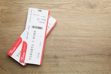 Photo of Travel agency. Flight tickets on wooden table, top view. Space for text