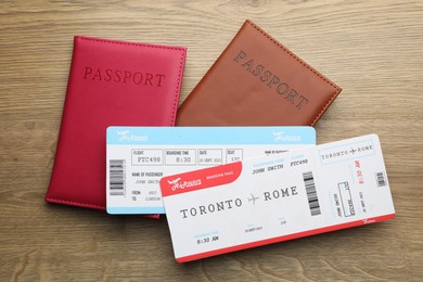 Photo of Travel agency. Flight tickets and passports on wooden table, flat lay