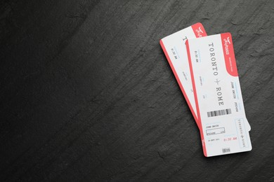 Photo of Travel agency. Flight tickets on dark textured table, top view. Space for text