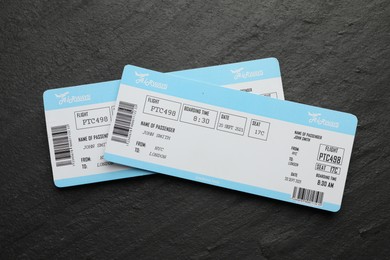 Photo of Travel agency. Flight tickets on dark textured table, top view