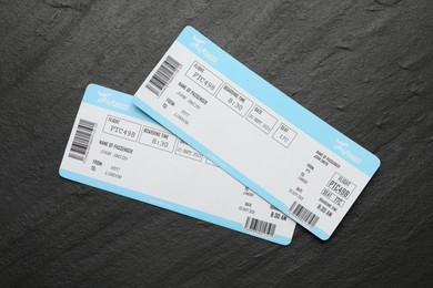 Photo of Travel agency. Flight tickets on dark textured table, top view