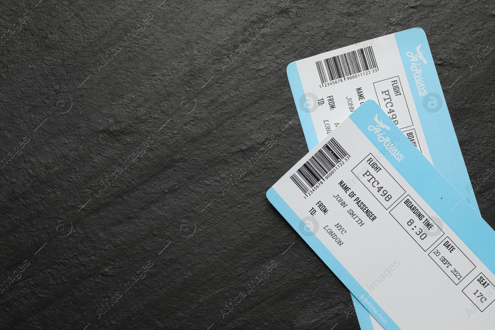 Photo of Travel agency. Flight tickets on dark textured table, top view. Space for text