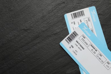 Photo of Travel agency. Flight tickets on dark textured table, top view. Space for text