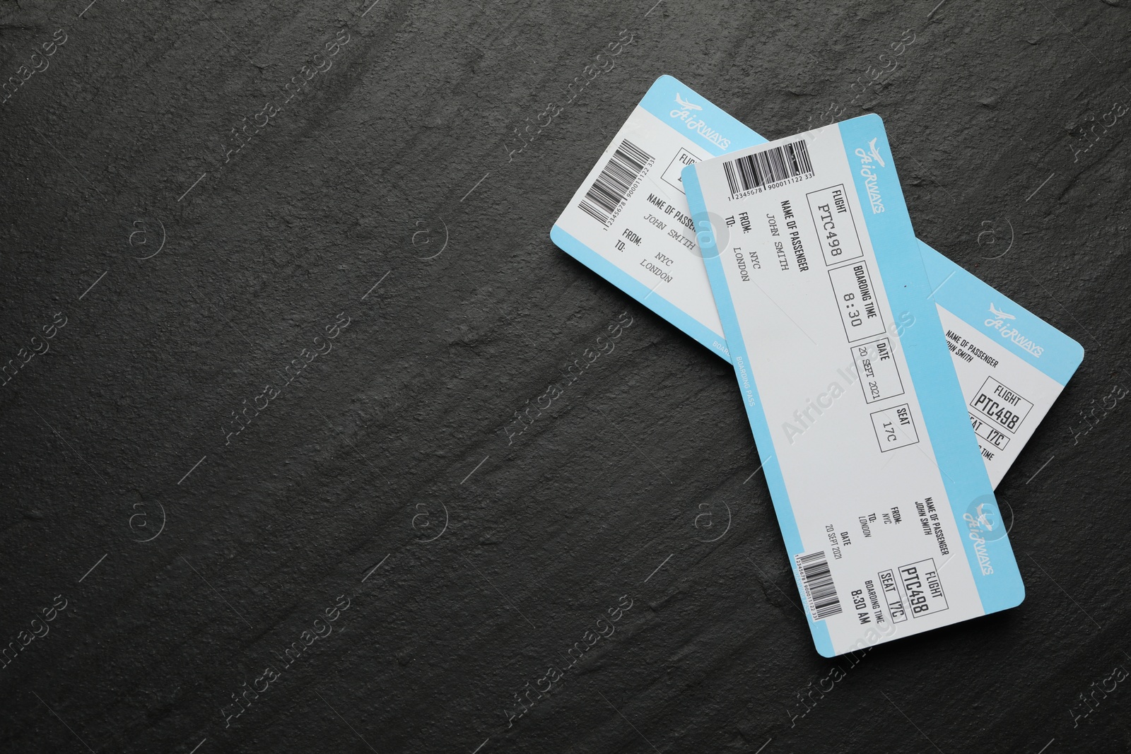 Photo of Travel agency. Flight tickets on dark textured table, top view. Space for text