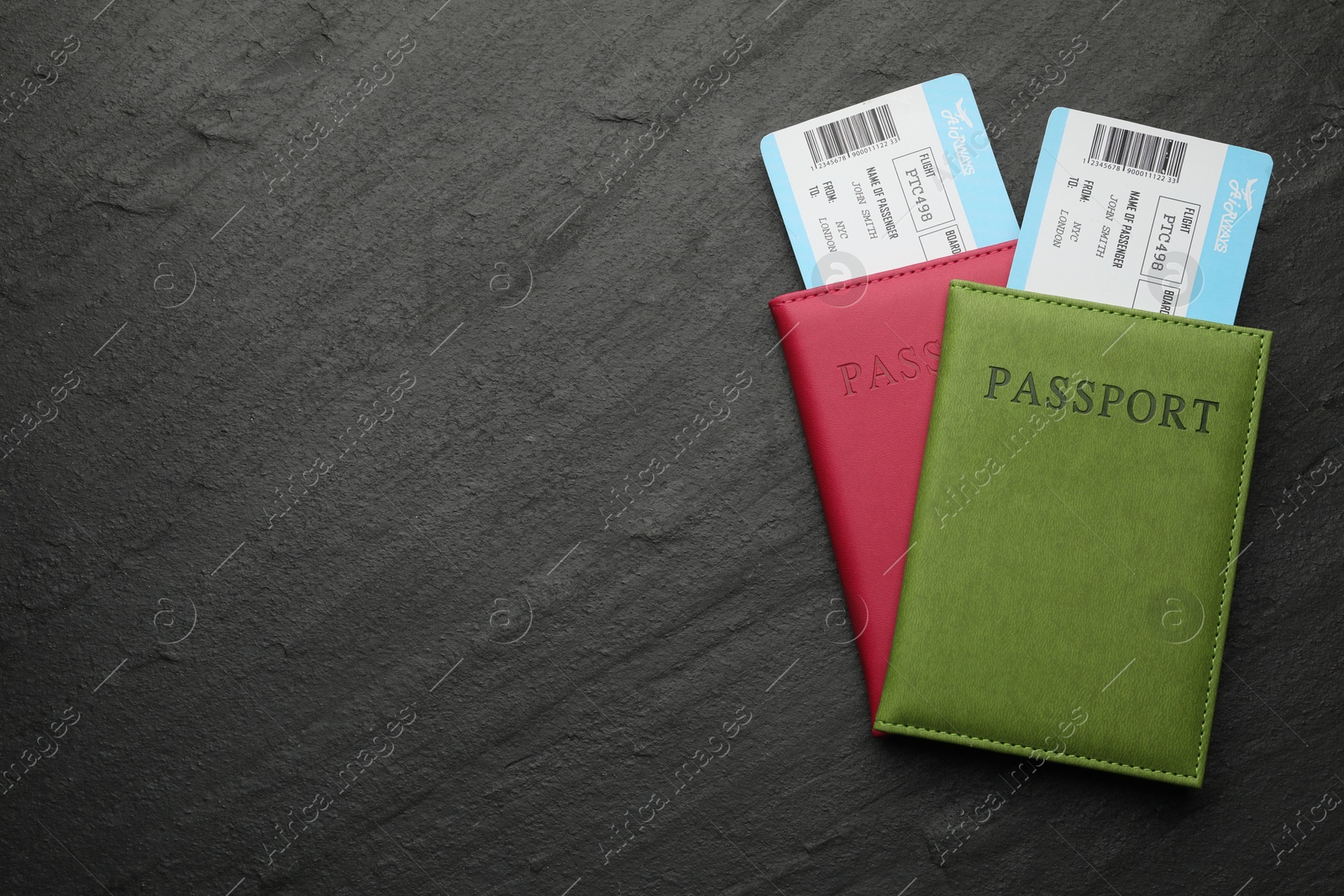 Photo of Travel agency. Flight tickets and passports on dark textured table, top view. Space for text