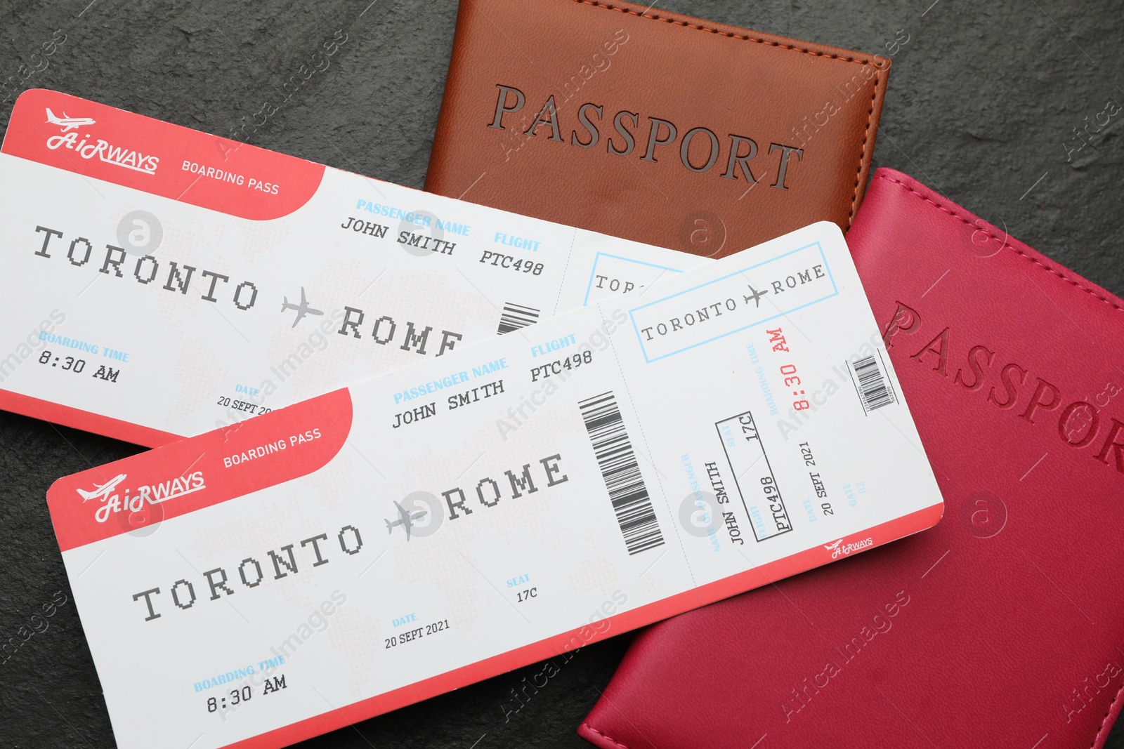 Photo of Travel agency. Flight tickets and passports on dark textured table, flat lay