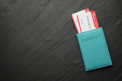 Photo of Travel agency. Flight tickets and passport on dark textured table, top view. Space for text