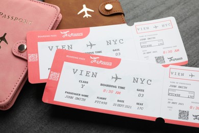 Photo of Travel agency. Flight tickets and passports on dark textured table, closeup