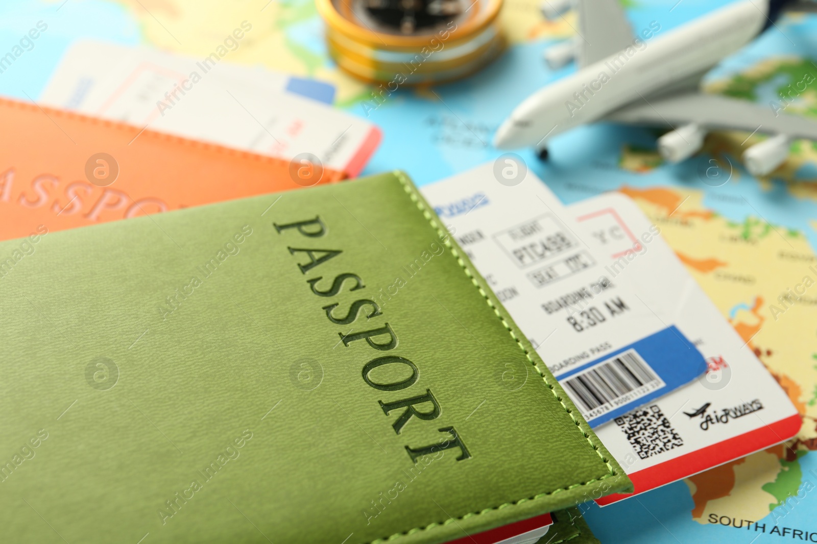 Photo of Passports with tickets and plane model on world map, closeup