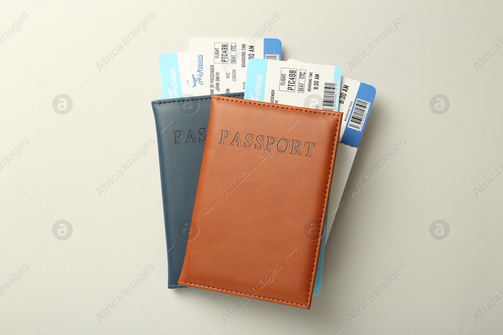 Photo of Passports with tickets on light background, top view