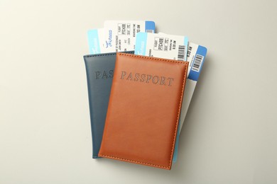 Passports with tickets on light background, top view