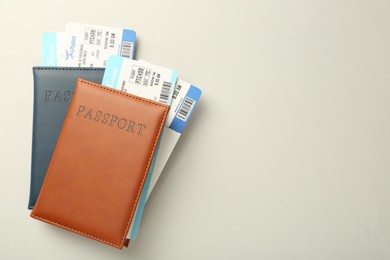 Photo of Passports with tickets on light background, top view. Space for text