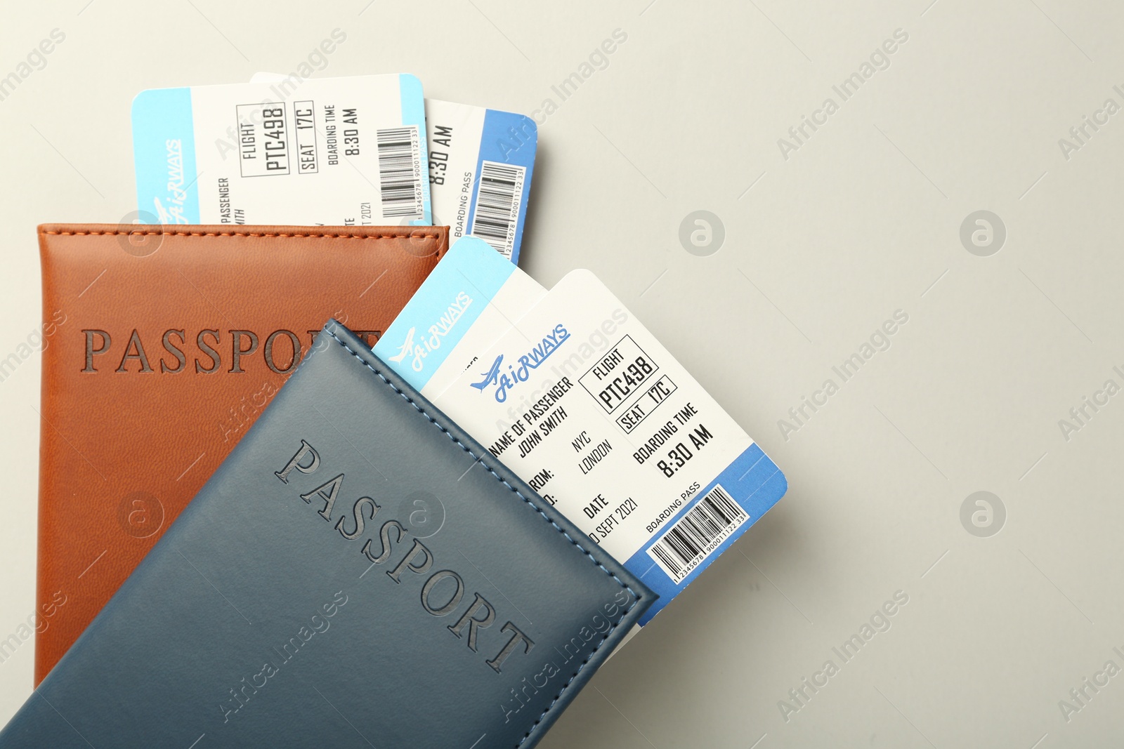 Photo of Passports with tickets on light background, top view. Space for text