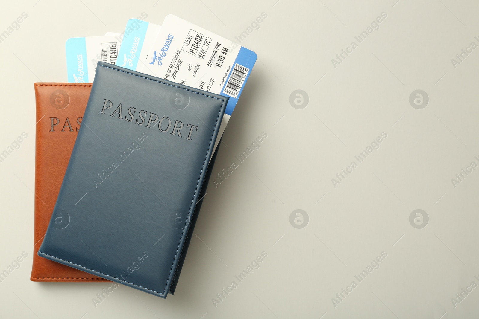 Photo of Passports with tickets on light background, top view. Space for text