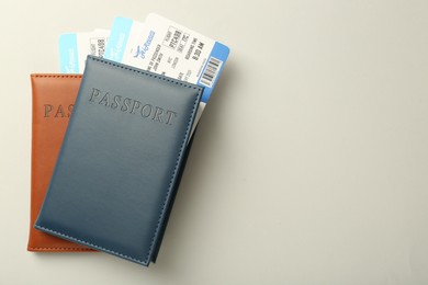 Photo of Passports with tickets on light background, top view. Space for text