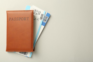 Photo of Passport with tickets on light background, top view. Space for text