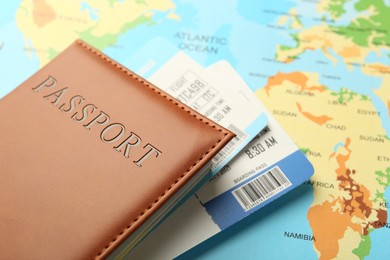 Photo of Passport with tickets on world map, closeup