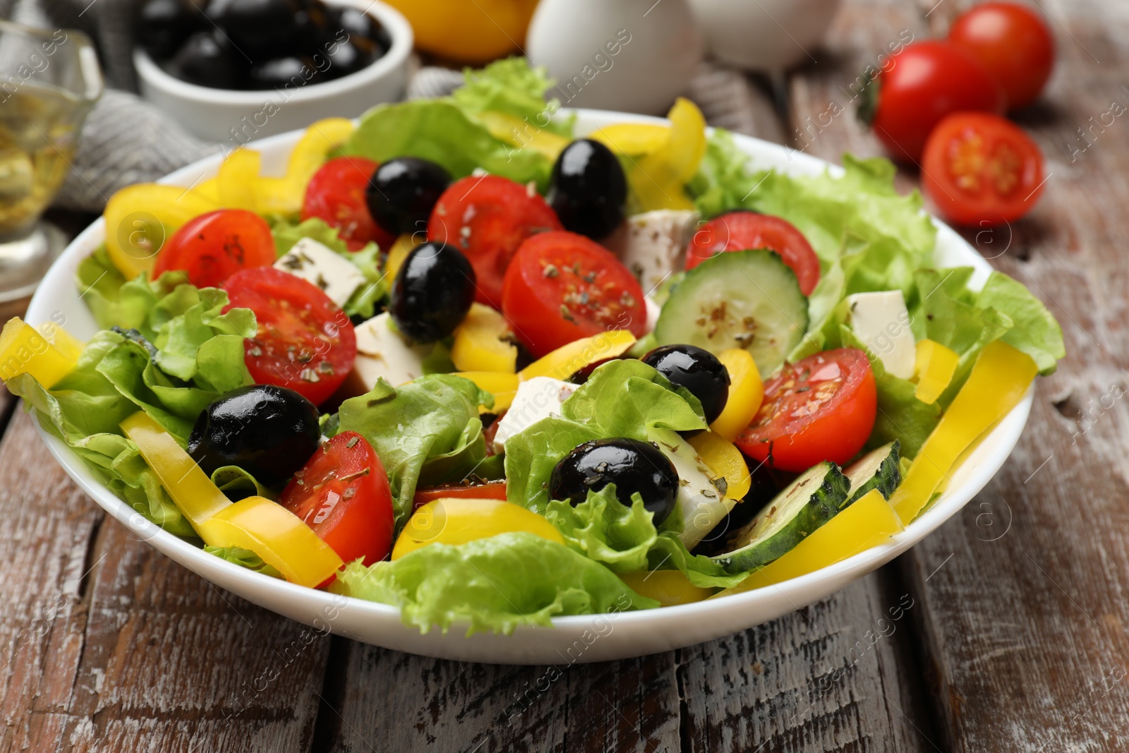 Photo of Delicious fresh Greek salad on wooden table, closeup