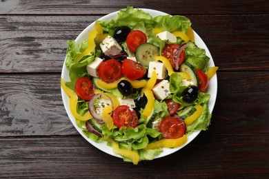 Photo of Delicious fresh Greek salad on wooden table, top view