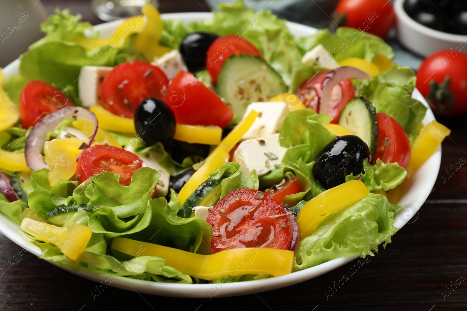 Photo of Delicious fresh Greek salad on wooden table, closeup