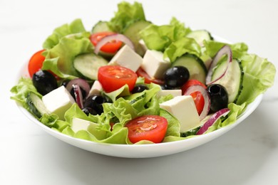 Photo of Delicious fresh Greek salad on white table, closeup