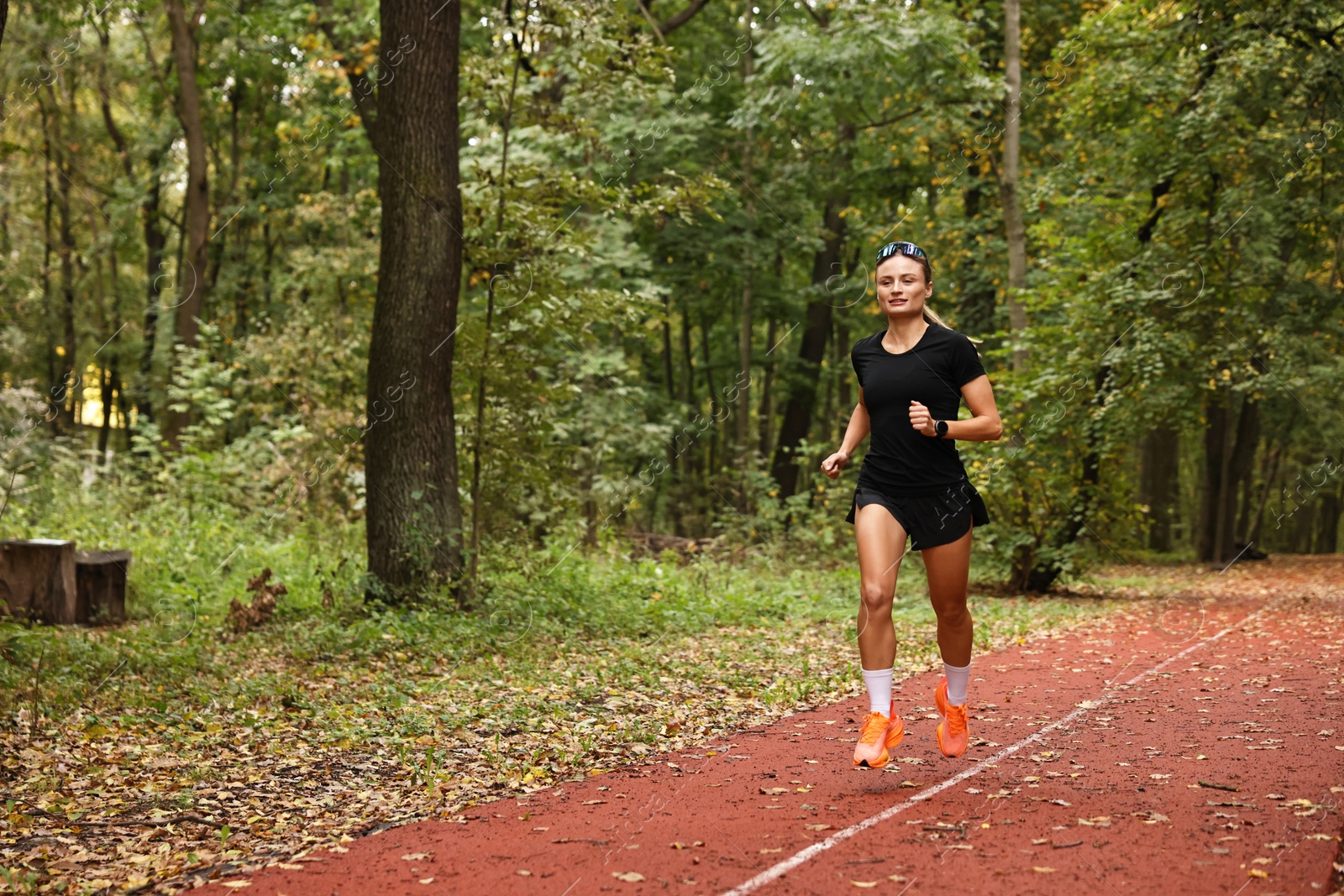 Photo of Athletic woman running in park, space for text