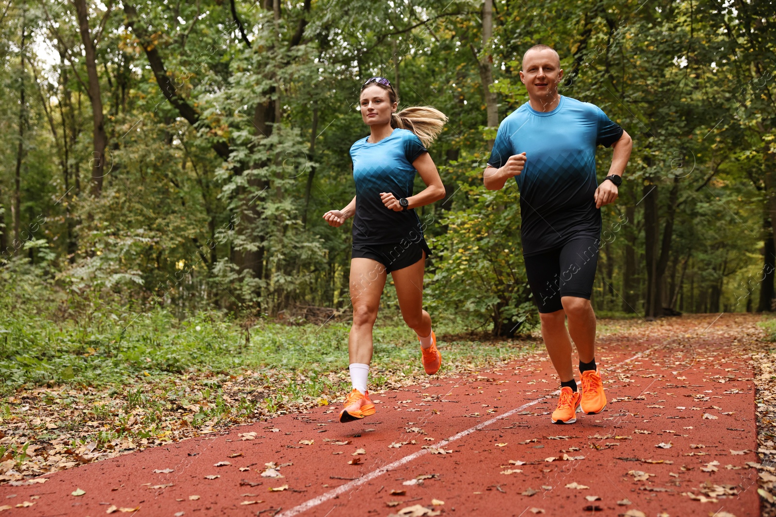 Photo of Athletic man and woman running in park