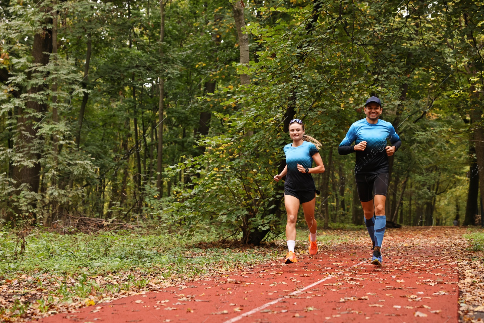 Photo of Athletic man and woman running in park, space for text