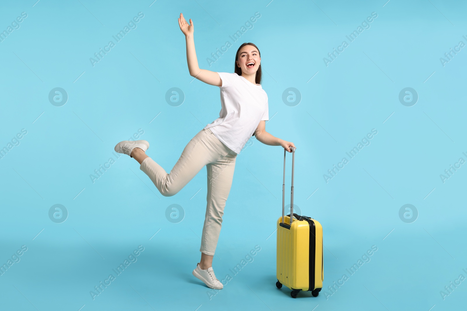 Photo of Woman with vintage camera and suitcase on light blue background