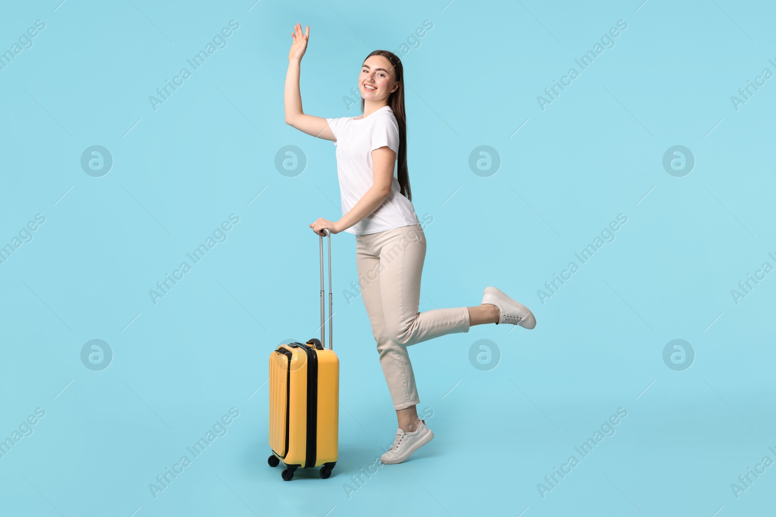 Photo of Woman with suitcase on light blue background