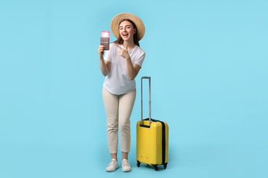 Photo of Woman with ticket, passport and suitcase on light blue background