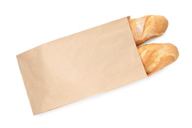 Photo of Freshly baked baguettes in paper bag isolated on white, top view