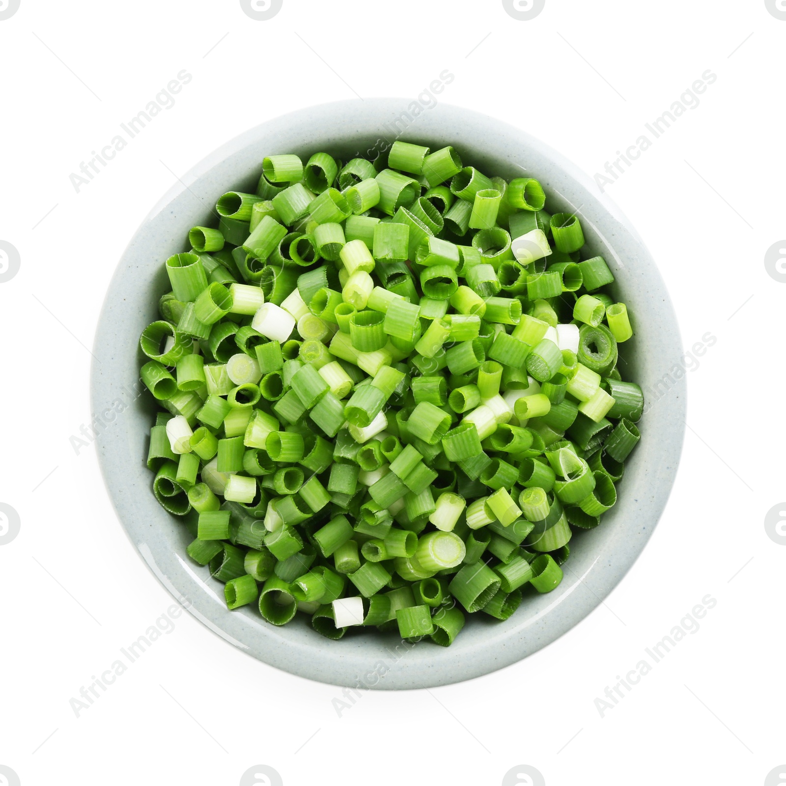 Photo of Chopped fresh green onion in bowl isolated on white, top view