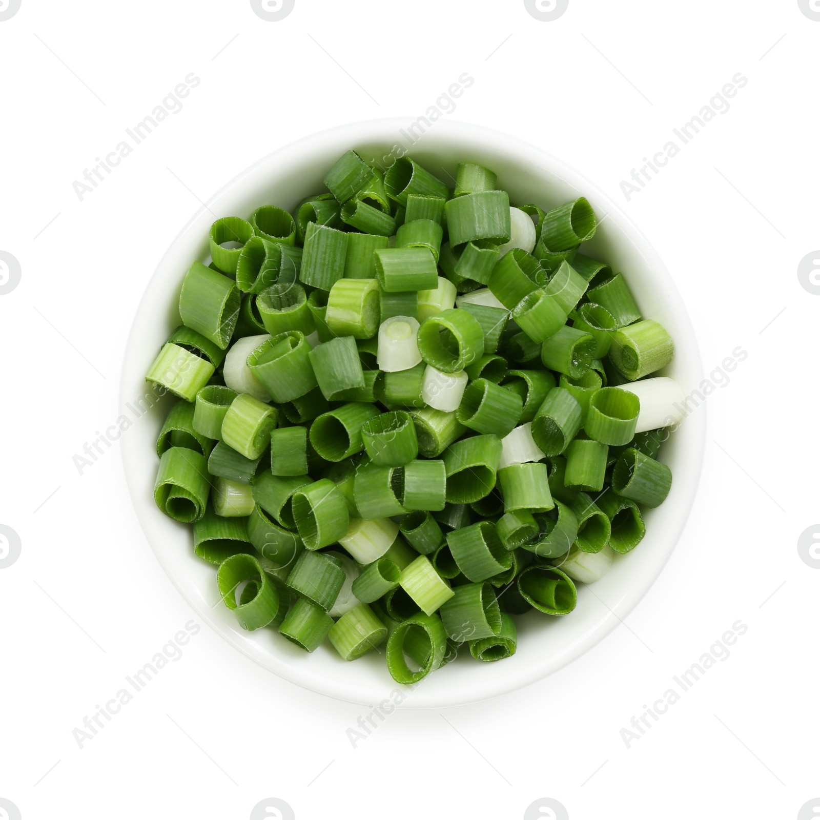 Photo of Chopped fresh green onion in bowl isolated on white, top view