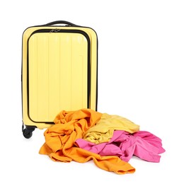 Photo of Yellow suitcase and pile of different messy clothes isolated on white