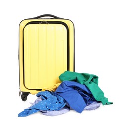 Photo of Yellow suitcase and pile of different messy clothes isolated on white