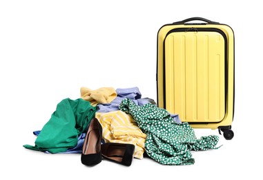 Photo of Suitcase and messy pile of clothes on grey background