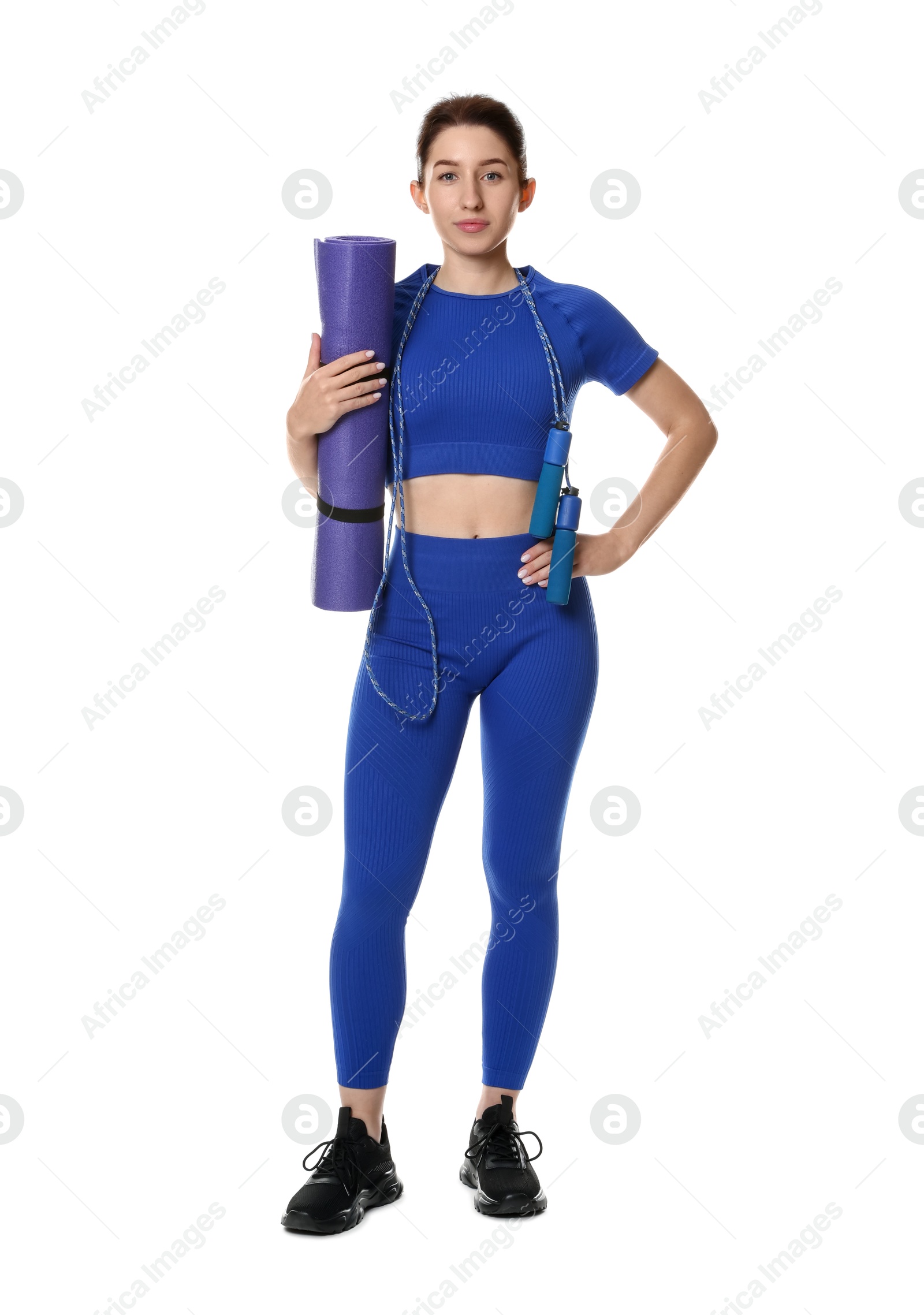 Photo of Woman in sportswear with fitness mat and skipping rope on white background