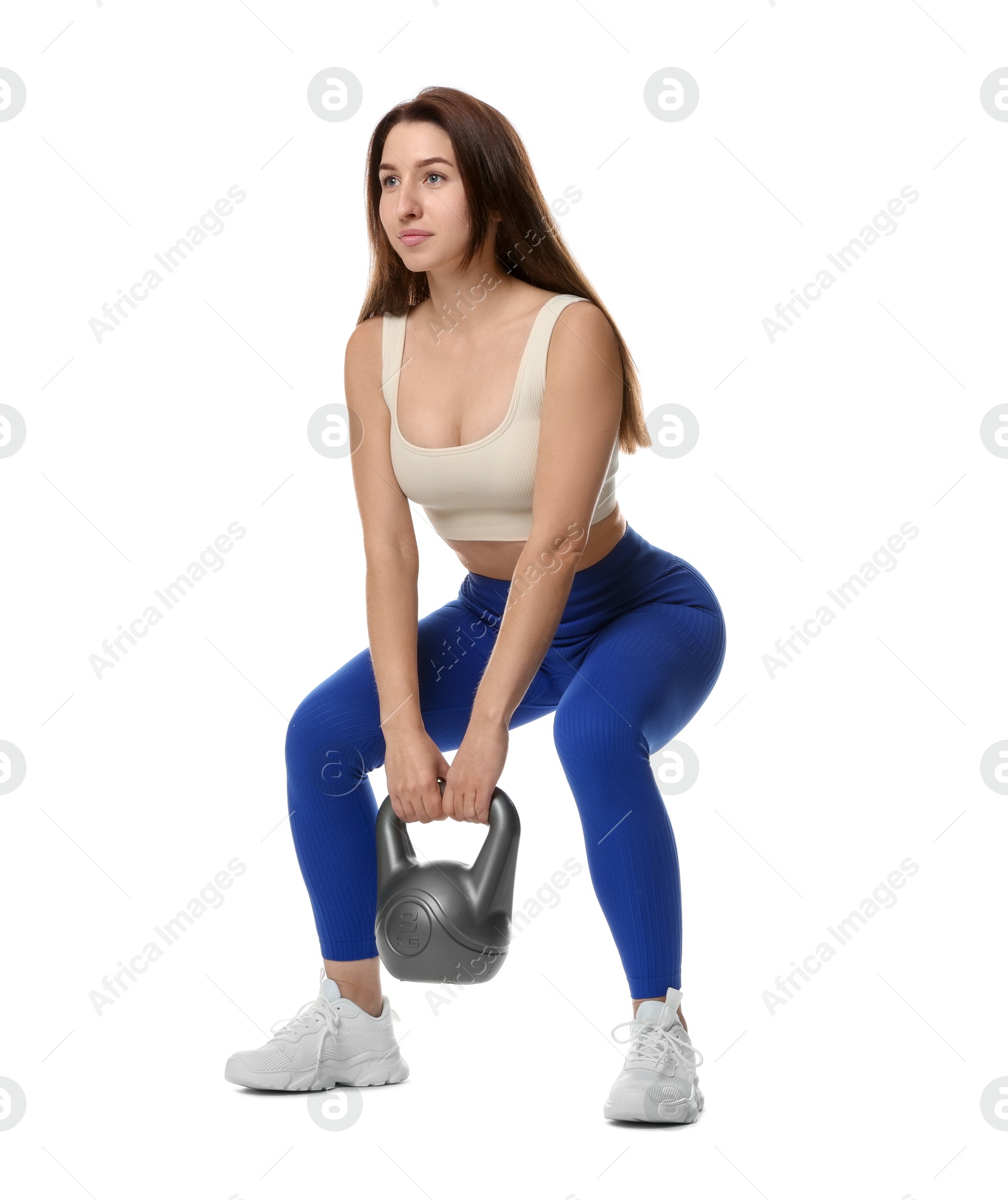 Photo of Woman in sportswear exercising with kettlebell on white background