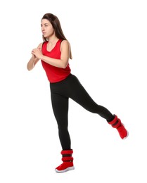 Woman in sportswear exercising with ankle weights on white background