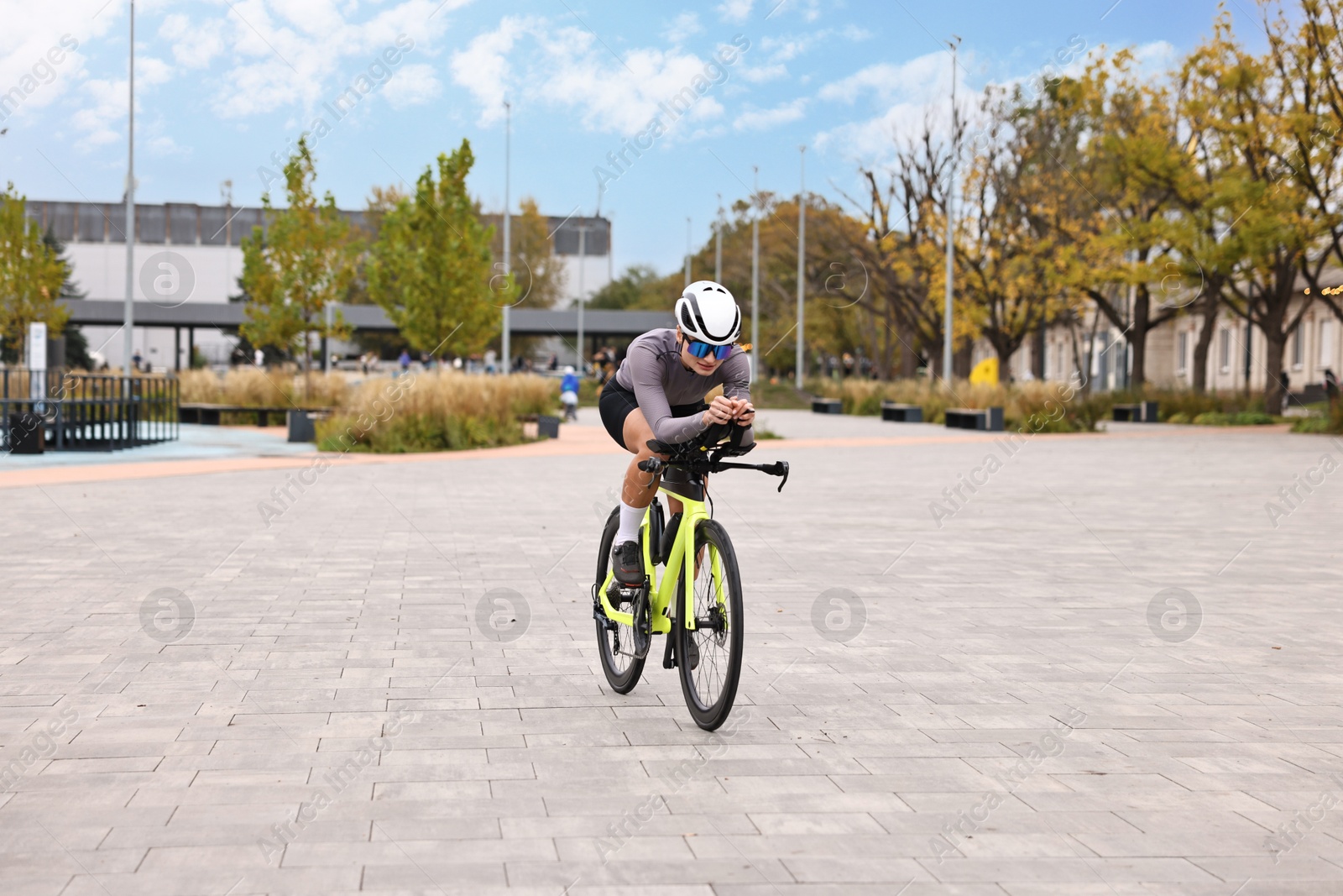 Photo of Young athletic woman with helmet riding bicycle outdoors