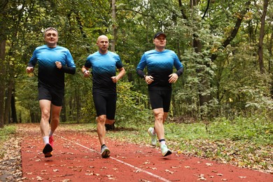 Photo of Group of athletic people running in park