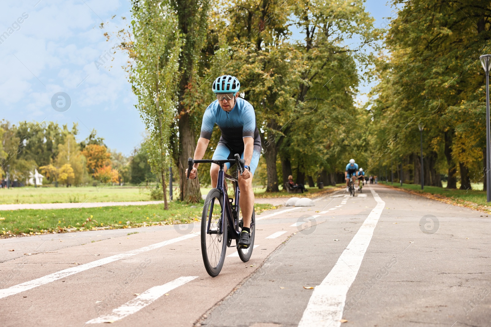 Photo of Group of athletic people riding bicycles outdoors