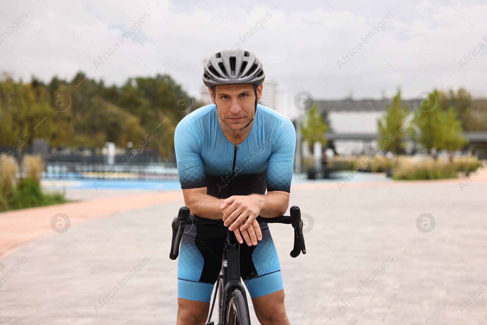 Photo of Athletic man with helmet and bicycle outdoors