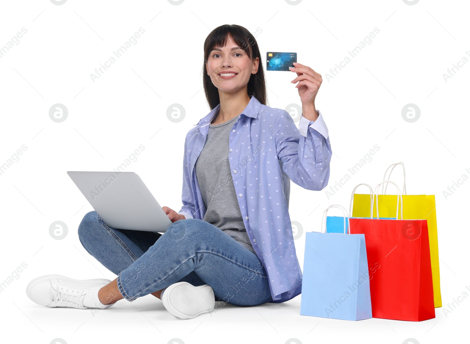 Photo of Internet shopping. Happy woman with credit card, laptop and colorful bags on white background