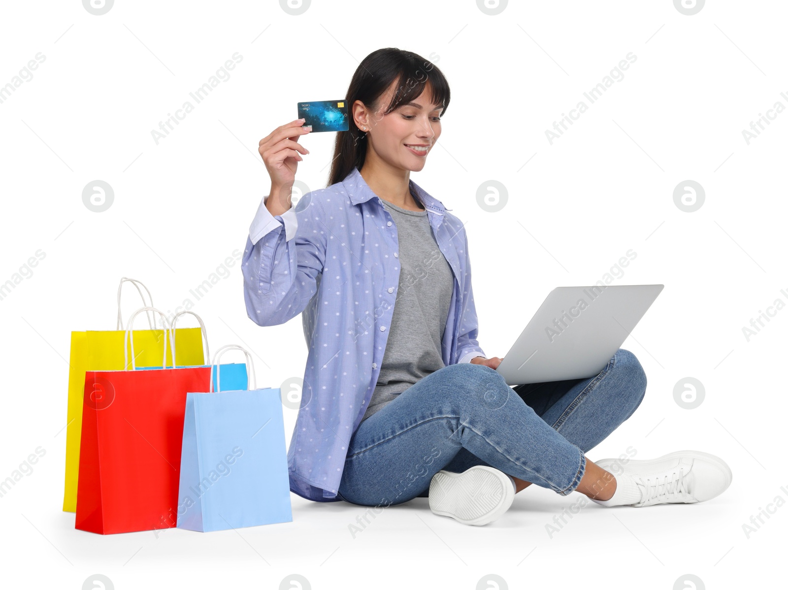 Photo of Internet shopping. Happy woman with credit card, laptop and colorful bags on white background