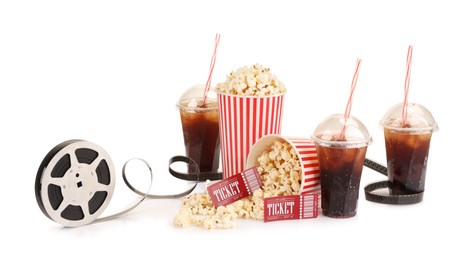 Photo of Tasty popcorn, film reel, soda drinks and movie tickets isolated on white